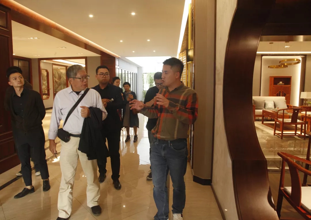 双洋红木董事长王海洋给众人讲解产品，介绍产品理念