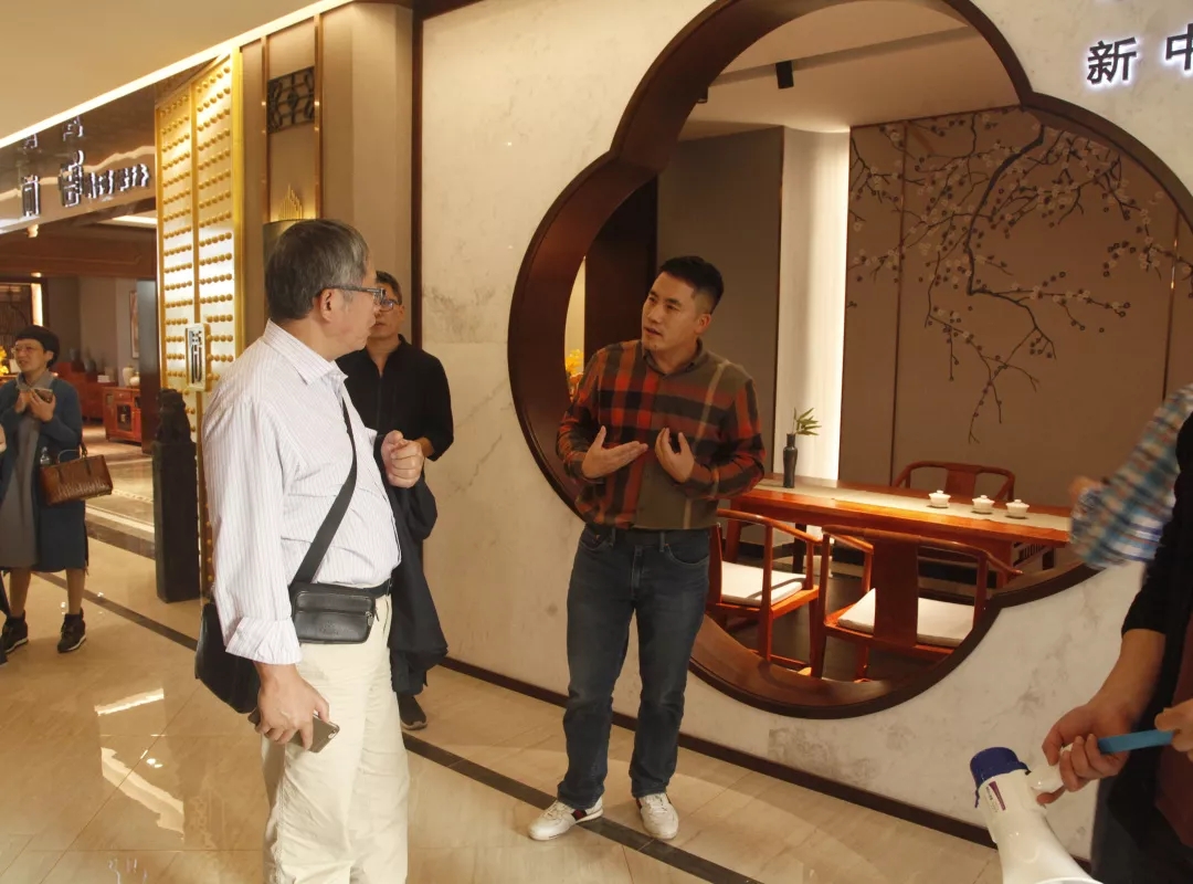 双洋红木董事长王海洋给众人讲解产品，介绍产品理念